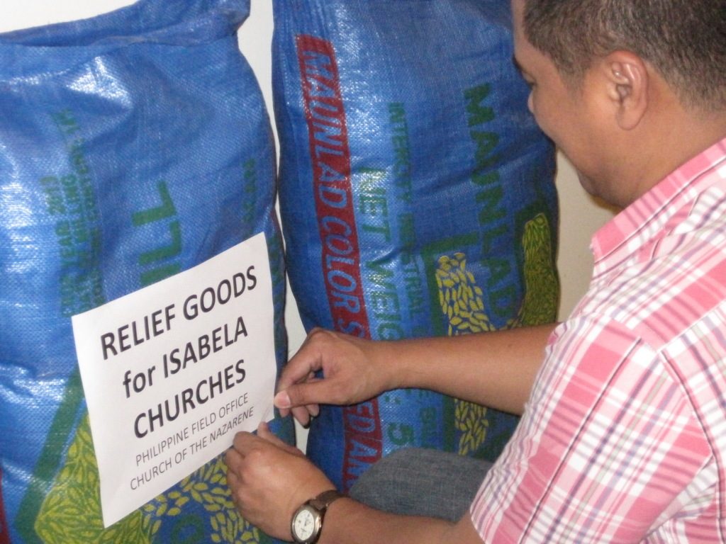 Philippine - Micronesia Field Strategy Coordinator, Stephen Gualberto, labels the rice bags for delivery.