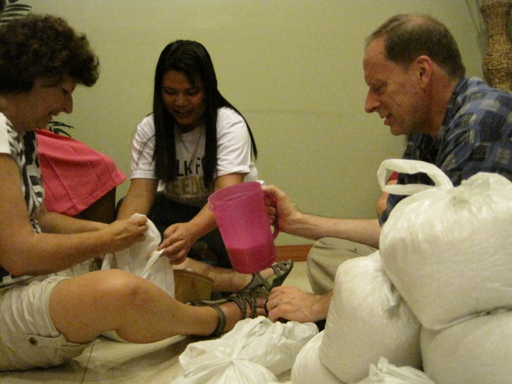 Filipino Field Office Staff and Eastern Michigan District Work and Witness team members pack rice bags to be delivered to Nazarene families displaced by Typhoon Labuyo