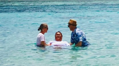 2 people baptizing an adult female